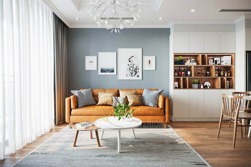 Tường được dán bằng giấy màu xám xanh và được trang trí bởi các bức tranh, góp phần tạo nên sự hiện đại cho phòng khách.